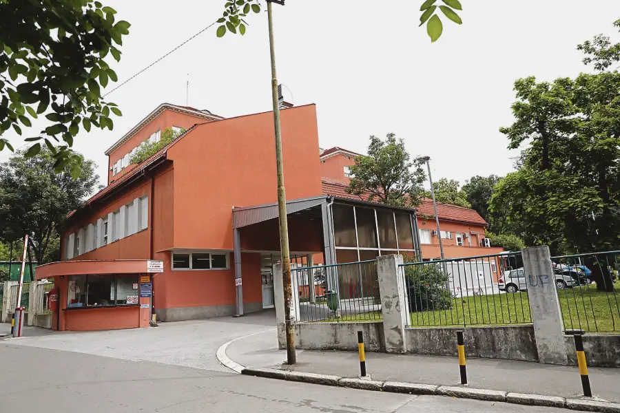 Glavni ulaz i fasada zgrade KBC Zvezdara (Gradska bolnica) u Beogradu sa prilazom i portirnicom.