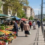 Cvetkova pijaca na Zvezdari sa tezgama, kupcima i tramvajem u blizini.