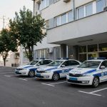 Tri policijska vozila parkirana ispred zgrade.