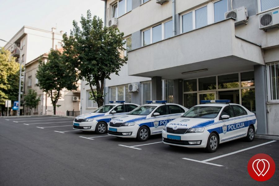 Tri policijska vozila parkirana ispred zgrade.